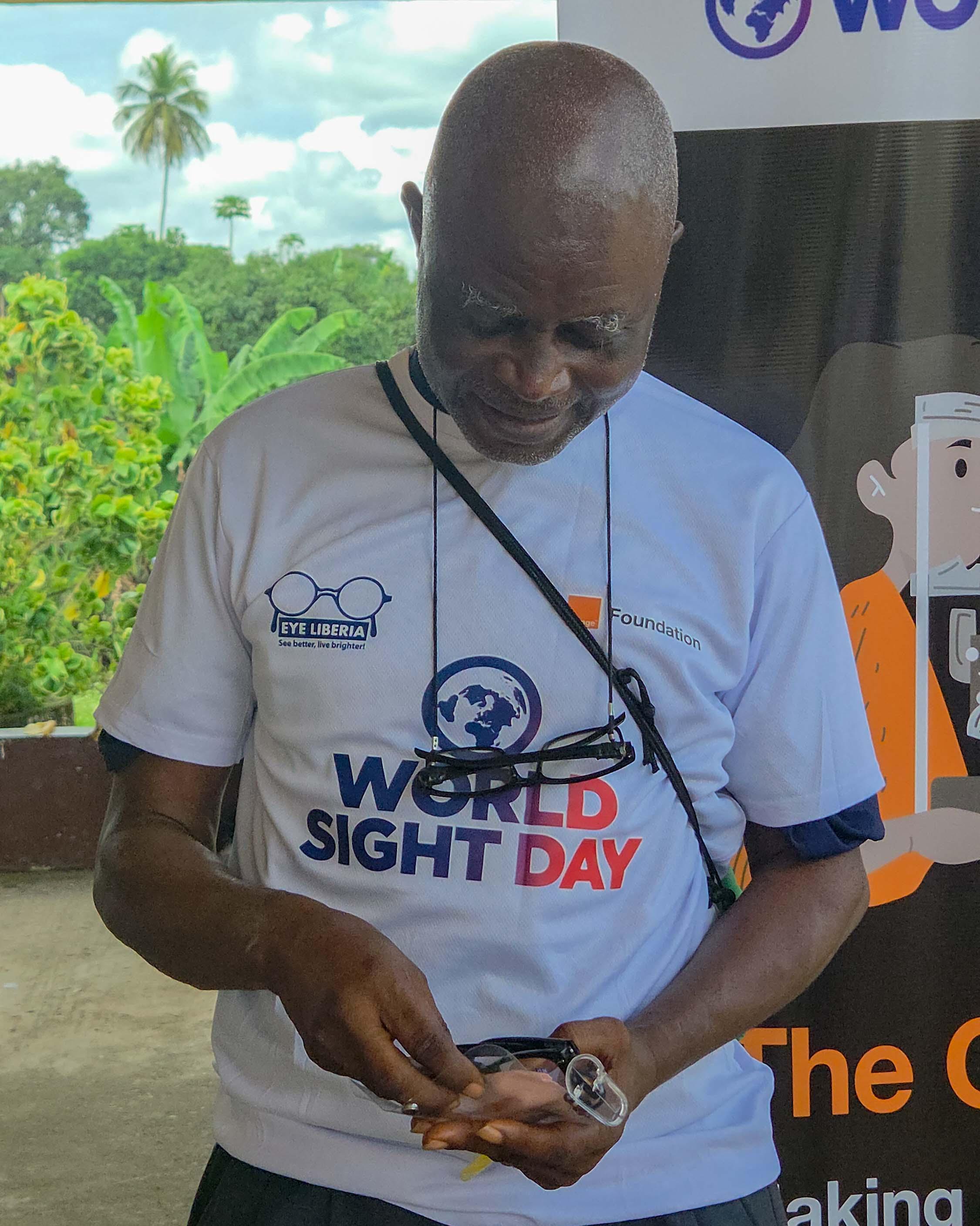 Elder placing his glasses back in its container after being told it was not okay to hold it in your hands if it's not being worn.